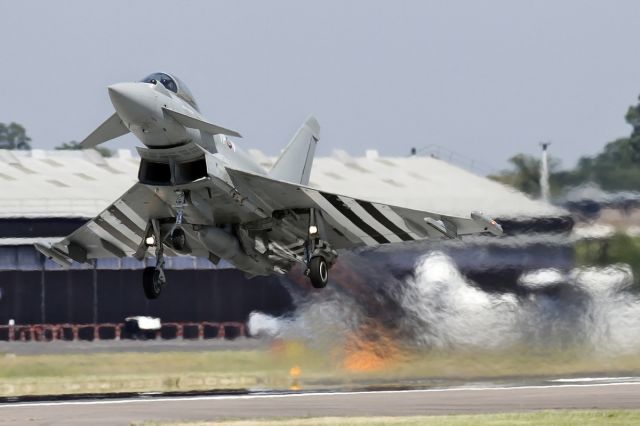 GLA308 — - [cn.BS059]. 'Blastoff' with Flt Lt Noel Rees at the controls of this Eurofighter EF-2000 Typhoon FGR4 ZK308/TP-V from 29 Squadron. Marked as a 1940s Hawker Typhoon with type C1 roundels, invasion stripes and Sqd codes, commemorating the 70th anniversary of D-Day. Seen here making one hell of a noise at the Farnborough EGVA/FFD International Airshow, Hampshire England 18.7.2014.