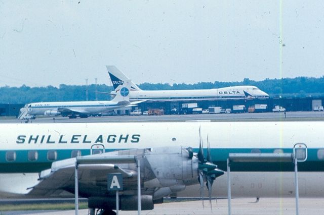 Lockheed L-188 Electra — - Lockheed Electra of travel club Shillelaghs in front of Pan Am Boeing 707 and Delta Boeing 747 at KIAD circa 1968-70