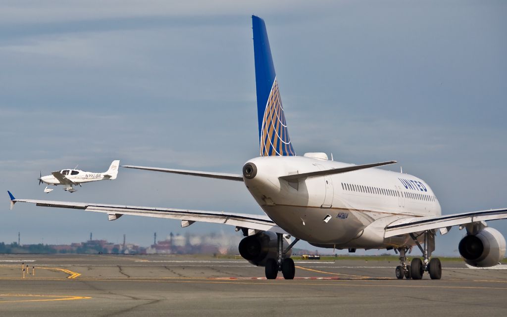 Cirrus SR-22 (N190SR) - 4L landing  as United A320 N416UA waits and watches 