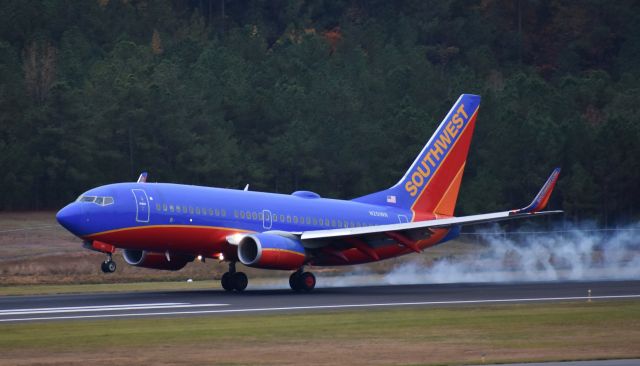 Boeing 737-700 (N251WN) - Smoking the mains on 5R.  Taken from the top of the parking deck at RDU.  11/12/17.