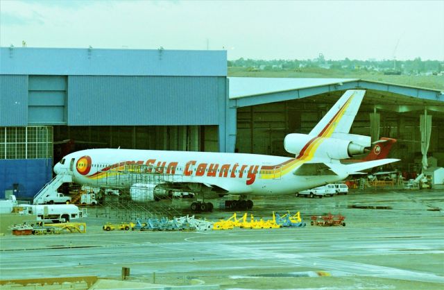 McDonnell Douglas DC-10 (N573SC) - KPHX - faded brain, but probably April 1999 or earlier at DynaCorp?? modification facility - there was always a jet here I'd never seen before and lucky for me this soon to be ex Sun Country -10 was on the ramp. Im guessing but I think this was one of a few -10s that went to Skyservice Airlines. They also better get a new Air-stair truck as that last climb into the Jet looks difficult. There were 2 mini DC-9s on the right of the -10 I'll post a photo of that later as that has a UAL 737 rolling by with the 2 DC9s in the shed. yes, it is raining, rare for PHX the times I had been there. This building was eventually torn down a few years later and I was not happy on my next visit when I saw that the building had been removed.