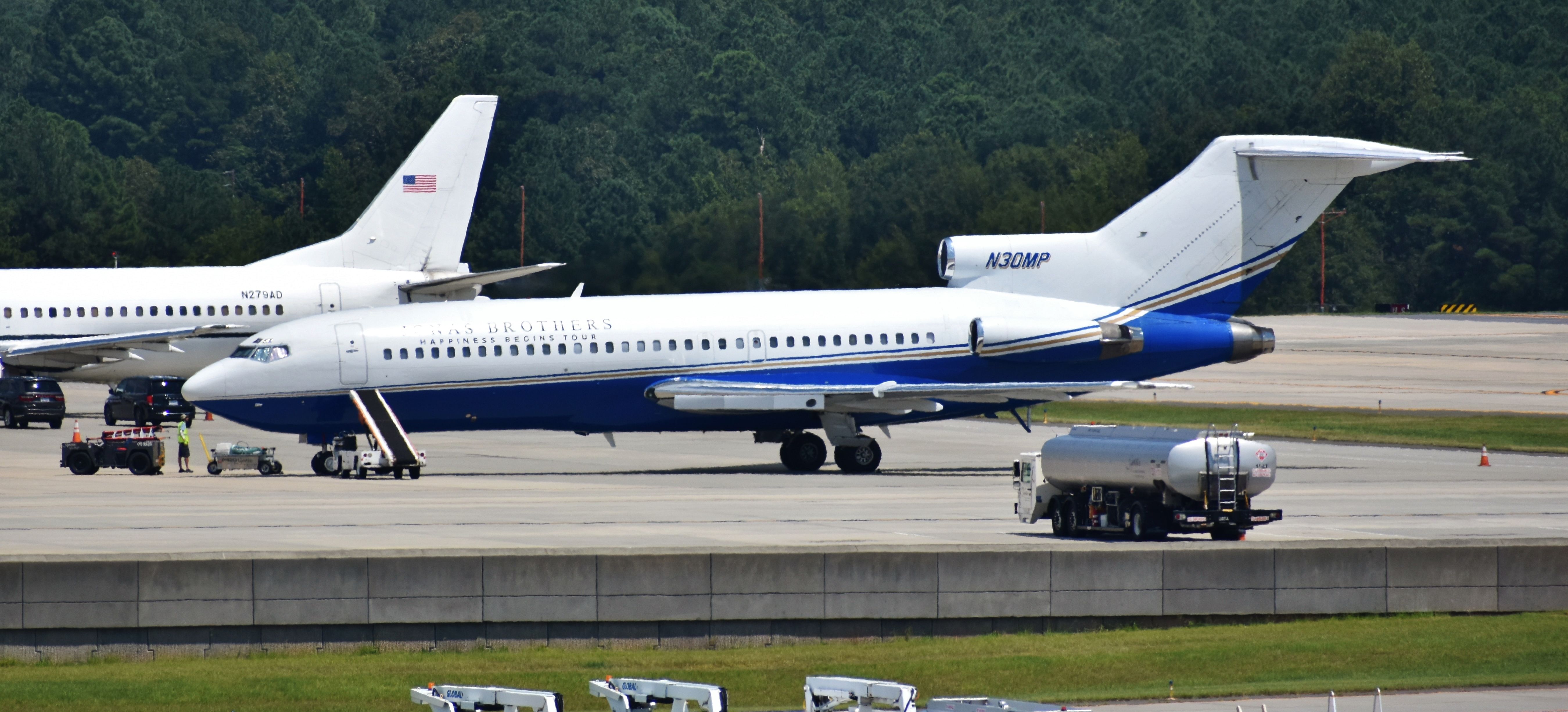 Boeing 727-100 (N30MP) - Yes, it's got some heat interference. Yes, it isn't in flight. However, how could I not put her up here for posterity? Though I missed the landing, this classic 727 - originally built for Pan Am - is now a cushy bird, flying the Jonas Brothers around. I was the only girl at the airport that was there for the plane only. Oh well. (Note the feds and their 734 loading prisoners beside them!) From the RDU parking deck, 8/14/19.