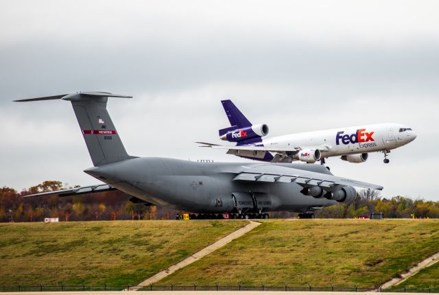 McDonnell Douglas DC-10 (N361FE) - C-5A 69-0005 waits to take off for her very last flight while a Fedex MD-10 is on extremely short final.