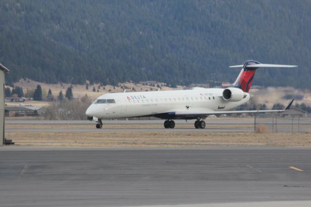 Canadair Regional Jet CRJ-700 (N713EV) - N713EV taxiing from the runway at Butte as SKYWEST 4312 from KSLC with a magpie flying by.br /br /Taken 15:01, November 2, 2024 with a Canon EOS T2i and 70-300mm (300mm, 1/500, ƒ7.1, ISO 800)