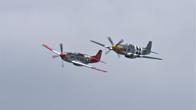 North American P-51 Mustang (N5087F) - Historic Flight Foundations P-51B "Impatient Virgin" #N5087F (Ser#42-106638) and Heritage Flight Museums P-51D "Val-Halla" #N151AF (Reg#45-11525) make a high speed pass over runway 34L on North American Aviation Day, 6/9/12.