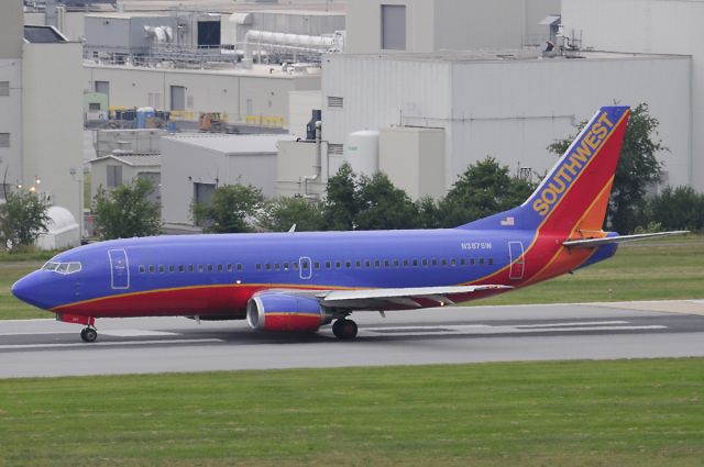 BOEING 737-300 (N387SW) - Seen at KBWI on 7/11/2009, this aircraft was involved in an explosive decompression incident two days later, on 7/13/2009.  A football-sized hole opened up just in front of the vertical stabilizer.  It was operating as WN2294 from KBNA to KBWI, and made an emergency landing in KCRW.  No injuries. (it was dark & overcast that day, so the photo is average)