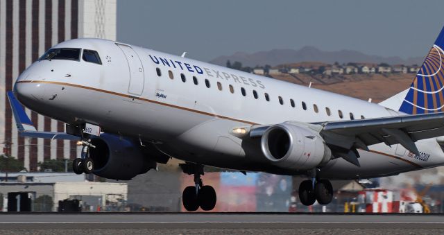 EMBRAER 175 (long wing) (N602UX) - A heartbeat away from touching the mains to the 17L concrete.