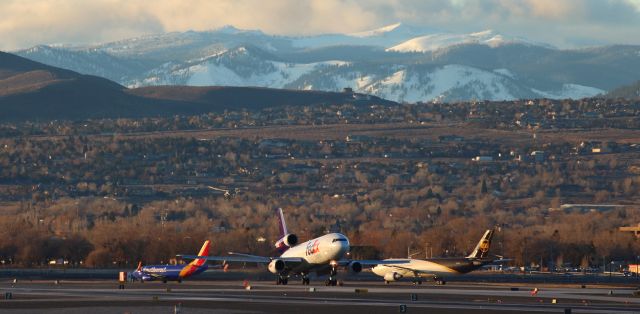 McDonnell Douglas DC-10 (N304FE) - This morning snap catches Fed Exs DC-10 "Claire" (N304FE) a heartbeat away from touching down on Reno Tahoe Internationals only open runway (34L-16R) to complete a morning flight from KMEM.  In the background, two of the aircraft (Southwests N7718B and UPSs N171UP) in a three-plane departure queue wait for Claire to land.