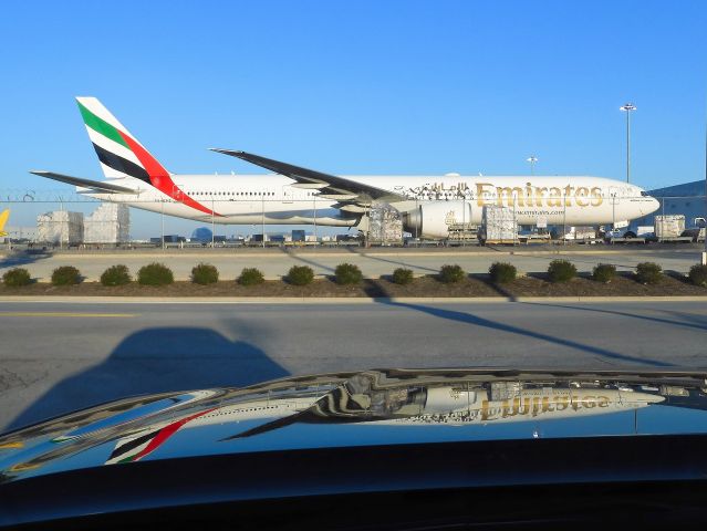 BOEING 777-300 (A6-EPZ) - Nice reflection off the hood of my truck. Shot through my windshield.