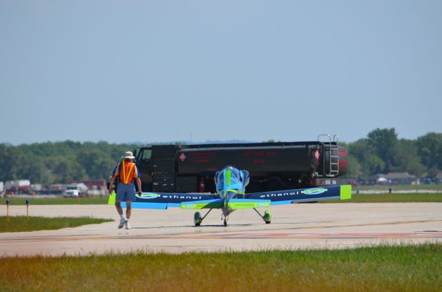 — — - Deke Slayton Airfest June 2014. Vanguard Squadron team member taxiing. Did not realize the juxtaposition until later - kind of funny - ethanol facing jet fuel. The one does not replace the other but it is still a little funny. I searched their web site to confirm aircraft type. They give all the aircraft specifications except the type and model! Do they fly RV12s?