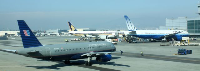 Airbus A320 (N427UA) - A320 in foreground starts taxiing to runway, following pushback from gate.