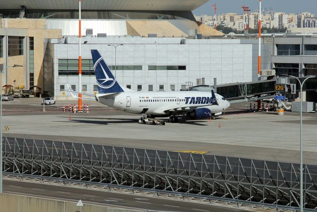 Boeing 737-700 (YR-BGI) - 04/01/2019:br /Back-side service area of gate E2G on terminal 3,  Tarom YR-BGI Boeing 737-78J at the gate prior its flight to Bucharest.br /Or-Yehuda town houses on the far side backdrop, view due NW.