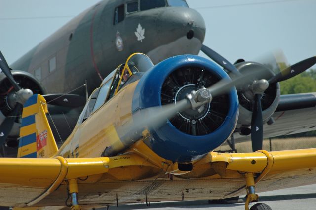 North American T-6 Texan (C-FVMG) - Canadian Car &amp; Foundry Co. Limited built version of North American Harvard Mk. IV (20412) returning from a flight at the Canadian Warplane Heritage Museum FlyFest on June 17, 2018 at CYHM. Note the Douglas DC-3 Dakota (C-GDAK - C/N 2141) in the background.