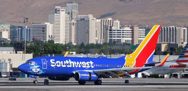 Boeing 737-700 (N705SW) - *** My most sincere "Thanks" to FA contributor Sara Orsi for posting yesterdays news release about the five Southwest fleetbirds with the all-new Shark Week nose art designs. After reading Saras post, I made it to RNO just ten minutes before this one arrived. Thank You, Sara. ***br /br /Southwests N705SW, which returned to service yesterday (9 July 2018) as one of the five SWA fleetbirds displaying five different Shark Week nose art "sharks," is clicked here just as the nose gear tires are about to touch down on to runway 16R at Reno Tahoe International about four hours ago to complete a KOAK-KRNO morning trip. The heat from the thrust reversers, combined with the triple-digit temperature out on the runway, created a bit of heat distortion, but the "Hammerhead" nose art is well defined.br /br /Info Note >> The other four Shark Week nose art designs are: "Great White" on N470WN, "Tiger" on N553WN, "Mako" on N961WN, and "Bull" on N947WN. 