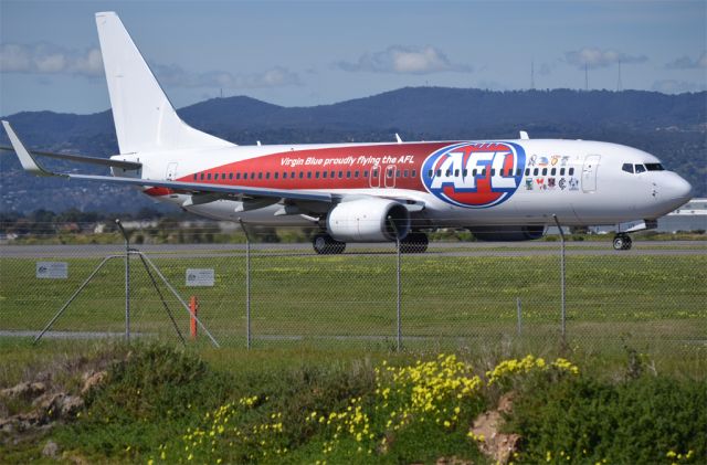 Boeing 737-800 (VH-VUY) - On taxi-way heading for runway 05. Special livery advertising Virgin Blues role as the official air carrier for the Australian Football League.