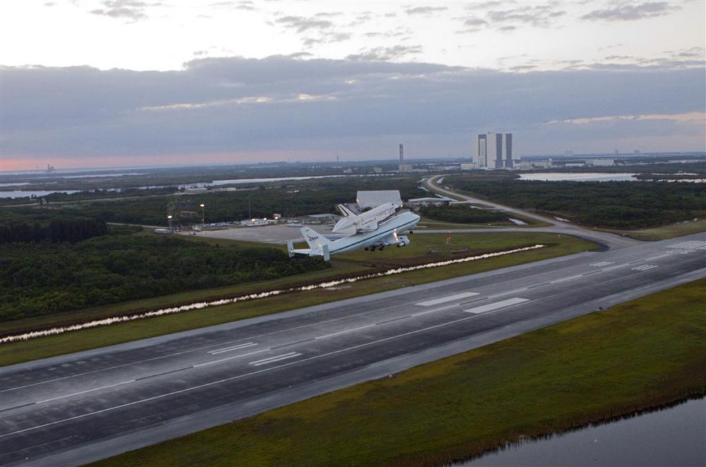 Boeing Shuttle Carrier (NASA905) - Climbing out of the SLF (KTTS) with the VAB in the background.