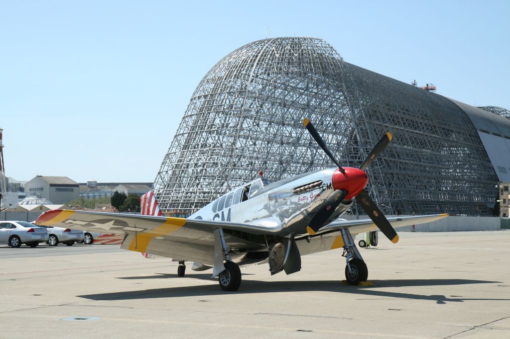 North American P-51 Mustang (N251MX) - Betty Jane at Moffett Field, CA in front of Hanger 1, originally built for the dirigible USS Macon -- being stripped of toxic siding 5/24/12.