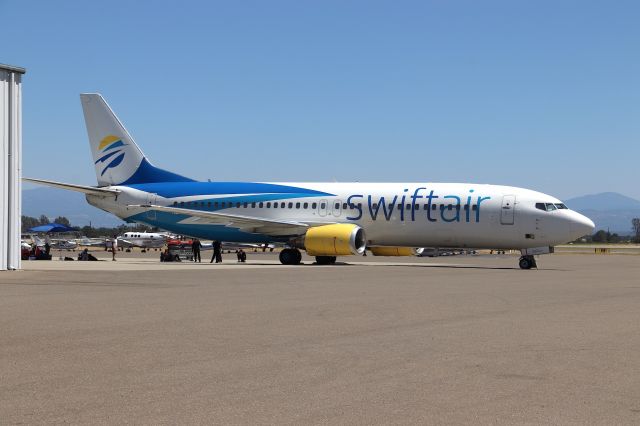 BOEING 737-400 (N285XA) - KRDD - This jet was here at Redding for about a week and did not move. This photo was clicked on a Saturday as I left work on OT and I cruised the airport 1pm. The funny part was the people on the other side looked like Grade "B" Actors in dress in 105 degree heat, play-babying trying to Karate Chop each other and related high-kicks/sweeps over the head all dress in black. Odd and strange for Redding ramp....addl: this 737-400 has built in Airstairs- in which I did not know this was still an option. As far as I know, there are no large jet airstairs at Redding Municipal.