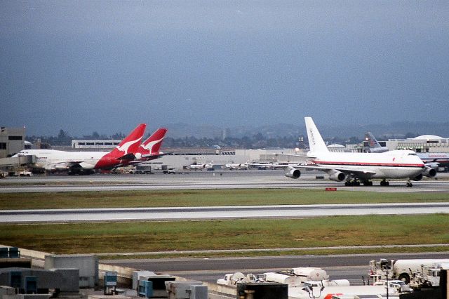 Boeing 747-200 (JA8107) - KLAX Japan cargo crossing 25R/L as a QANTAS 747SP and 747-200 load at the Intl terminal date apprx March 1988?
