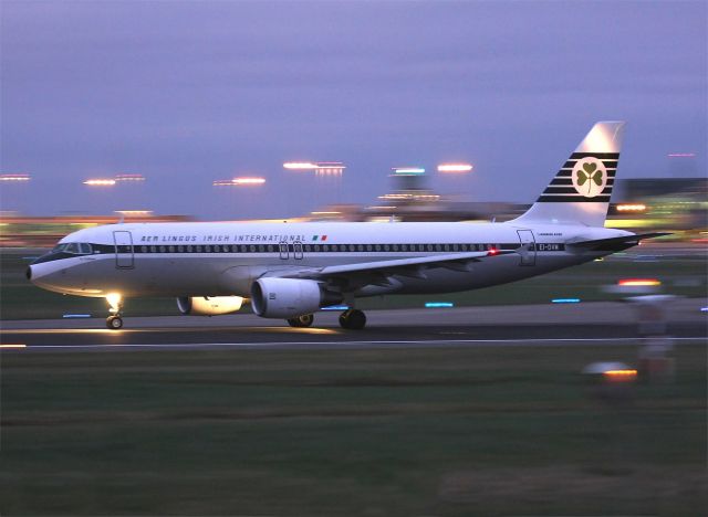 Airbus A320 (EI-DVM) - Painted in a retro livery, this Aer Lingus Airbus A320 departs Dublin, Ireland for London Heathrow at dusk