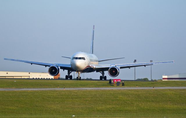 BOEING 767-200 (N252AU) - Arriving from Philadelphia to RON for routine maintenance. Notice the slope of the taxiway and runway in this photo and a shutter speed of 1/1000 has "stopped" the "worm" painted on the spinner of the right engine (to see engine rotation).