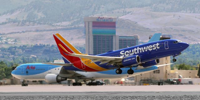 Boeing 737-700 (N7731A) - Off 34R and climbing away as, way over on the west side of the airport, a B763 taxies south on Alpha.