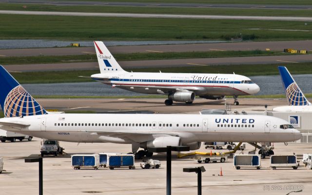 Boeing 757-200 (N570UA) - United Airlines Aribus A320 (Friendship One) special livery plane (N475UA) passes behind a Boeing 757-200 (N570UA) parked at gate 39 at Orlando International Airport (MCO).  United currently operates 10 gates in Terminal B Airside 3 at MCO.