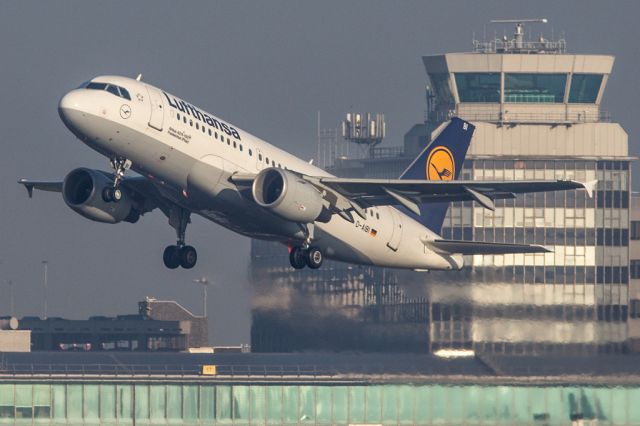 Airbus A319 (D-AIBI) - The thick fog earlier in the morning had cleared a fair amount, but still left some haze as DLH941 departed for Frankfurt.