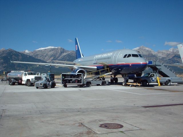 — — - United Airbus at JAC w/ Grand Tetons in background