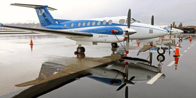 Beechcraft Super King Air 350 (N886UP) - A pair of Wheels Up Beechcraft King Air B350 fleetbirds, N886UP (foreground) and N841UP, are shown here parked on the Atlantic Aviation ramp just after a heavy rainfall had ended. The puddle of water drained off quite quickly (exactly as runway, taxiway, and parking ramp aprons are designed to facilitate) so I considered myself very lucky to be here to get this snap before the water drained away.