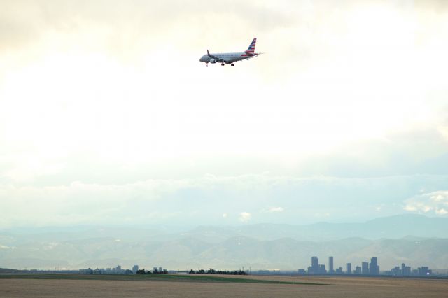 Embraer 170/175 — - Approach to 16R at KDEN under dark skies with Denver in the background.
