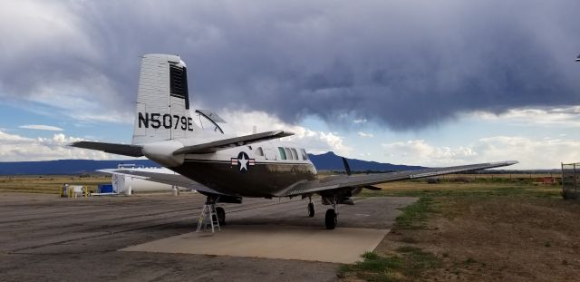 Beechcraft Queen Air (65) (N5079E) - 79E waiting for freight to arrive. Fishers Peak in the background.