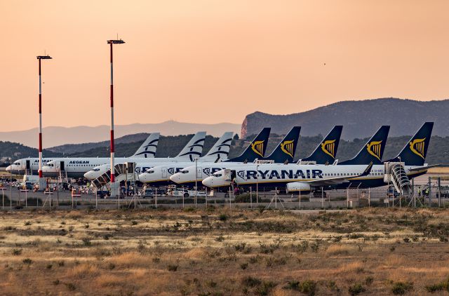 Boeing 737-700 (EI-EBX) - A row of Ryan Air 737-800s next to a few of the same from Aegean at Athens International Airport at sunrise