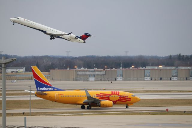 Boeing 737-700 (N781WN) - "New Mexico One" taxiing beneath departing CRJ.