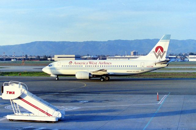 BOEING 737-300 (N307AW) - KSJC - Early AM departure for Phoenix AZ USA shows one of America West new 737-300s delivered new in the early 1990s. When America West hit the market mid 1980s they had 737-200s and quite a few. It was nice to see them move to the 737-300. This photo from the SJC Observation desk early 1990s. If I remember correctly, TWA handled the ramp services for AWA. LN 1823 delv new to America West Feb 1990.