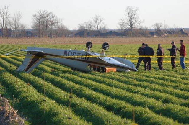 Piper Cherokee (N7230W) - Falling just short of the runway, N7230W made a soft landing in a rowed field. All three passengers survived with minor injuries.