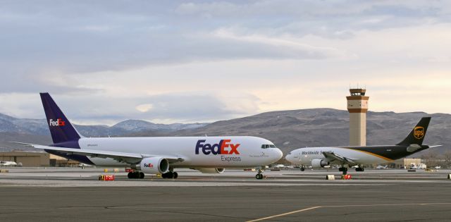 BOEING 767-300 (N269FE) - Captured in the final few moments of dawn light before the sun rises over those mountains in the background, Fed Ex's "Ashton" (N269FE) taxies south on Alpha toward Runway 34L for departure as UPS's N145UP rolls out after landing on 34L.