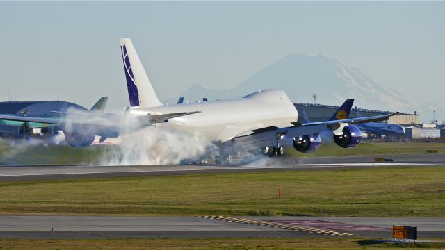 BOEING 747-8 (N770BA) - BOE573 makes tire smoke on landing Rwy 16R on 11/21/13. (LN:1437 cn 37564).  Mt Rainier can be seen in the distance.