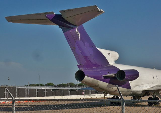 BOEING 727-200 (N487FE) - Closeup of the T-tail and hollow engine nacelles of former FedEx 727-227/Adv(F) N487FE. FedEx donated this 727 to the Austin Fire Department in 2013 and here she sits stripped of most of her former identity at the Northeast corner of the cargo ramp at AUS. The aircraft has since been relocated to the North end of a defunct Bergstrom AFB taxiway parallel to 18R/36L.br /Apr-08-2016