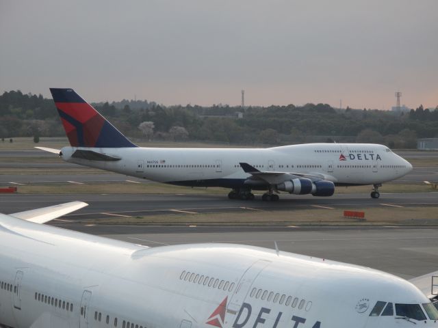 Boeing 747-400 (N670US) - N670US in the foreground and N667US taxiing to the gate