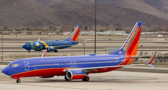 Boeing 737-800 (N8641B) - Southwests N8641B has already been pushed back and is about to taxi away from the gates while, in the background, SWAs "Nevada One" (N727SW) waits on taxiway Alpha for its company fleetbird to move out from the ramp.