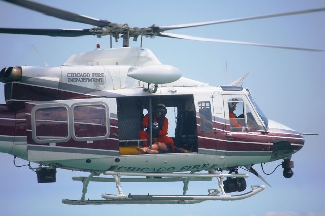 Bell 412 (N682FD) - A Chicago firefighter secures a mannequin after it was hoisted into the Bell 412EP during a Chicago Fire Department search and rescue demonstration in Lake Michigan behind the McCormick Center, Chicago, Illinois, on 26 Aug 2010.