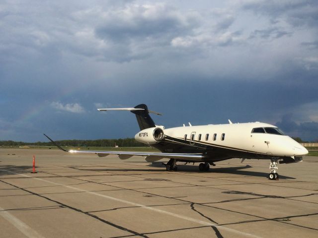 Bombardier Challenger 300 (N570FX) - A nearby storm rolls by KCGF, notice a slight rainbow to the left of the aircraft.  Taken on May 11 2016