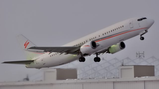 BOEING 737-400 (N803TJ) - Taking off to EWR/KEWR in light snow.