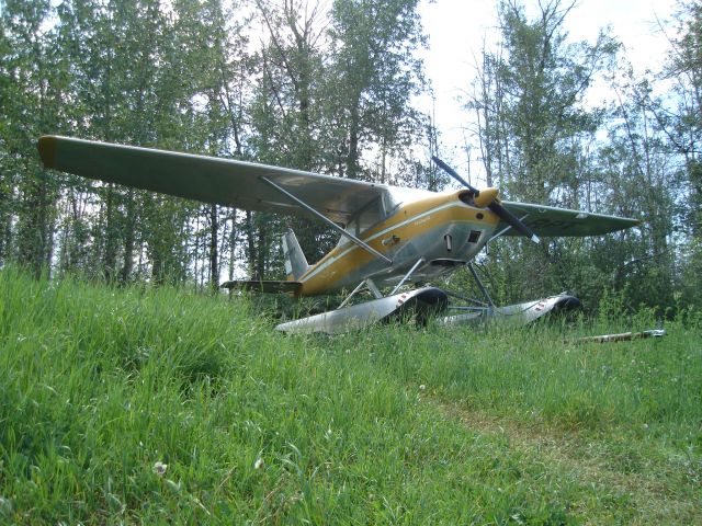 — — - Cessna float plane sits alongside the historic Snye at Fort McMurray, Alberta, Canada. One of the most noteworthy float plane locations in the world.