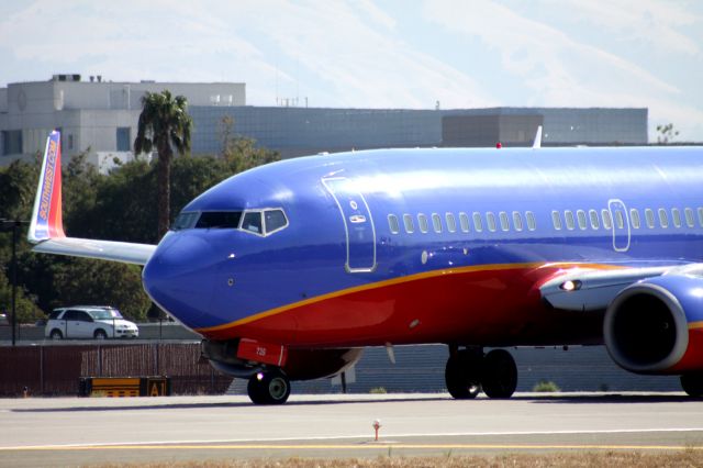 Boeing 737-700 (N739GB) - Holding on 30L for take off. Awaiting arrival of other SWA flight on 30R, prior to being cleared for take off.. Car in backgrond shows proximity of US 880 to runway.. Good thing there is a wall behind the jet.