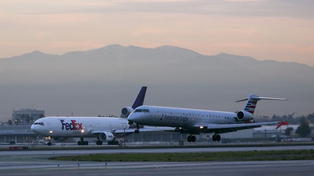 Canadair Regional Jet CRJ-900 (N951LR) - Race you...The American Eagle is landing on 25L and the FedEx freighter is taking off from runway 25R LAX. This is a photo happened by being at the right place at the right time. Los Angeles, California USA