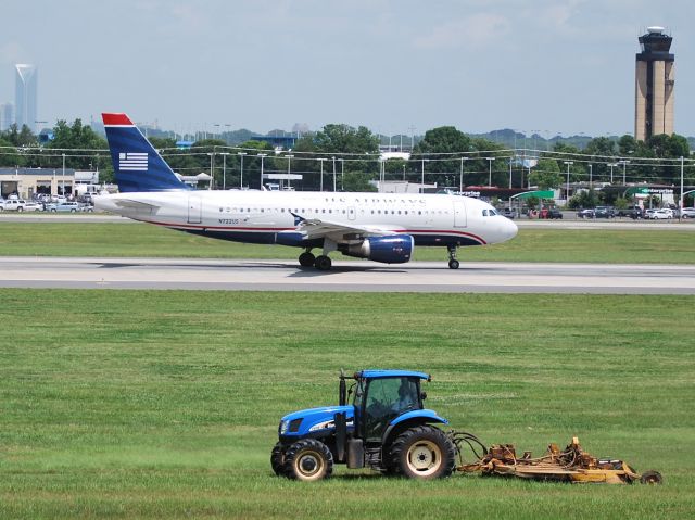 Airbus A319 (N722US) - The driver of the tractor enjoys an up-close view of this takeoff roll on runway 18C at KCLT - 6/25/13