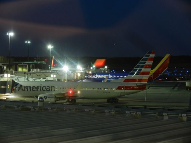 Boeing 737-800 (N947AN) - An American Airlines B737-800 And A Southwest B737-700 Sit At The Gate, In The Distance Is An Aircraft Approaching To Land