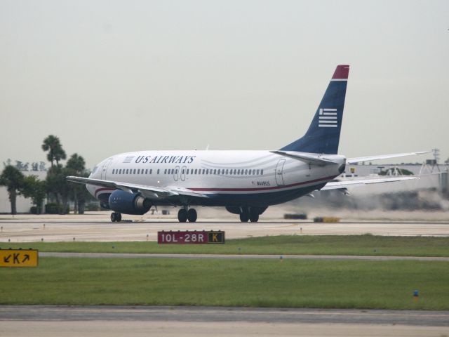 BOEING 737-400 (N449US) - Take off runway 28R.